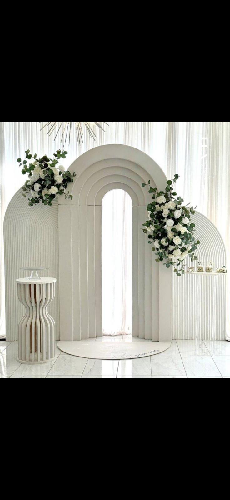 Arche de mariage blanche ornée de fleurs et d'eucalyptus, décoration de cérémonie élégante