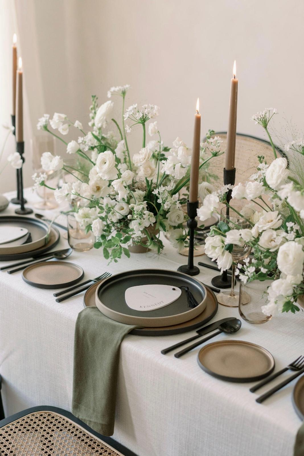 Table champêtre chic avec fleurs blanches, bougies et vaisselle artisanale