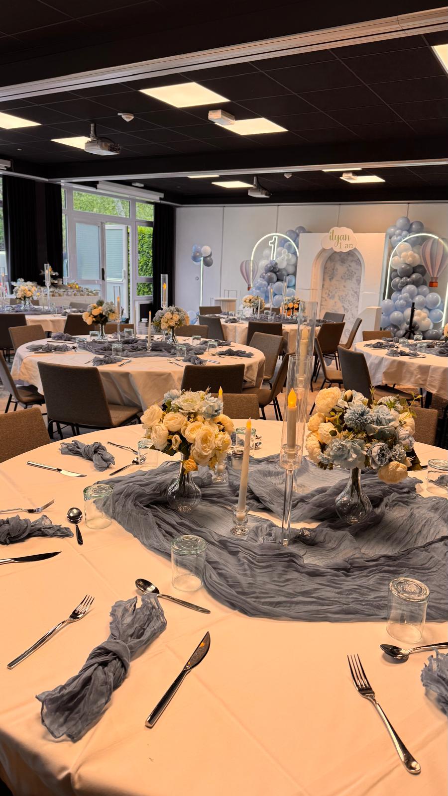 Table de réception dressée avec chemin de table en gaze, bouquets champêtres et bougies